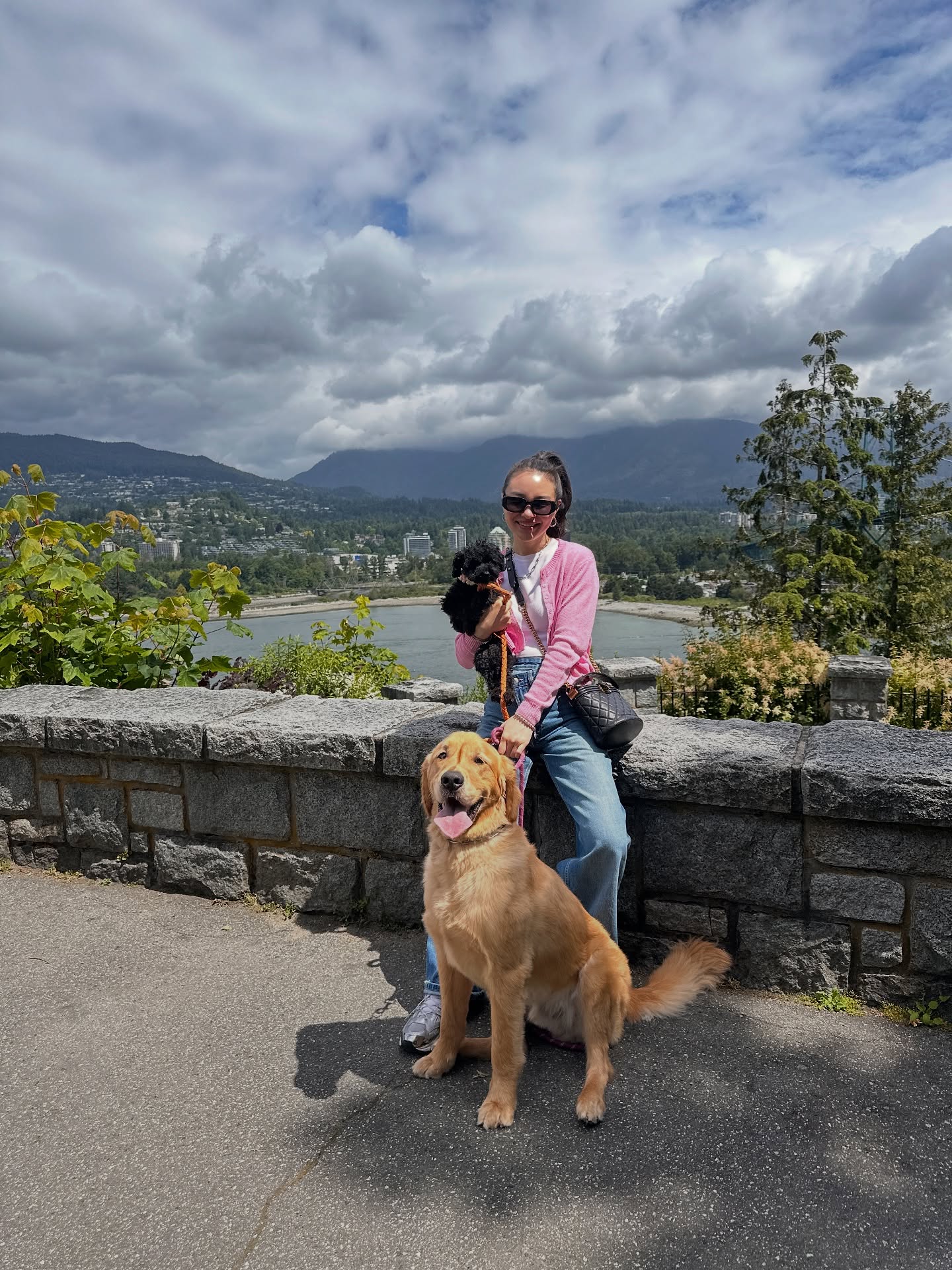 Kirsten outdoors with Oreo and Cookie, a golden retriever and a small black poodle